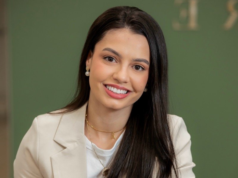 Fisioterapeuta Anny Caroline sorrindo, de blazer bege